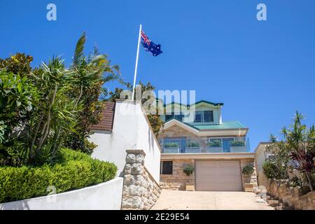 Sydney Küste freistehendes Haus in Avalon Beach mit üppigem Garten Und die australische Flagge, die auf der Fahnenstange, Sydney, Australien, fliegt Stockfoto