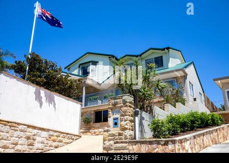 Sydney Küste freistehendes Haus in Avalon Beach mit üppigem Garten Und die australische Flagge, die auf der Fahnenstange, Sydney, Australien, fliegt Stockfoto