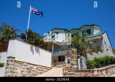 Sydney Küste freistehendes Haus in Avalon Beach mit üppigem Garten Und die australische Flagge, die auf der Fahnenstange, Sydney, Australien, fliegt Stockfoto