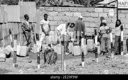 ADDIS ABEBA, ÄTHIOPIEN - 05. Januar 2021: Addis Abeba, Äthiopien, 30. Januar 2014, Männer und Frauen füllen Fässer an einem kommunalen Wasserauslass Stockfoto