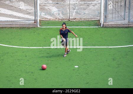 MEDELLIN, KOLUMBIEN - 23. Dezember 2020: Medellin, Kolumbien - 23 2020. Dezember: Eine junge Frau in Black Sportswear übt und spielt Fußball auf einer öffentlichen Fie Stockfoto