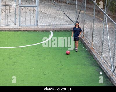 MEDELLIN, KOLUMBIEN - 23. Dezember 2020: Medellin, Kolumbien - 23 2020. Dezember: Eine junge hispanische Frau praktiziert und spielt Fußball auf einem öffentlichen Feld mit GRE Stockfoto