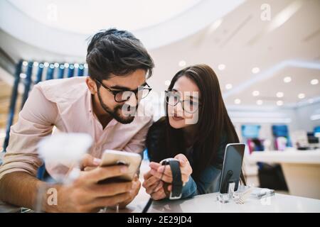 Junge schöne Paar in Tech-Shop kann nicht entscheiden, was zu kaufen. Stockfoto