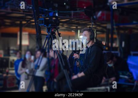 Maskierter Kameramann dreht eine Fernsehshow im Studio. TV Stockfoto