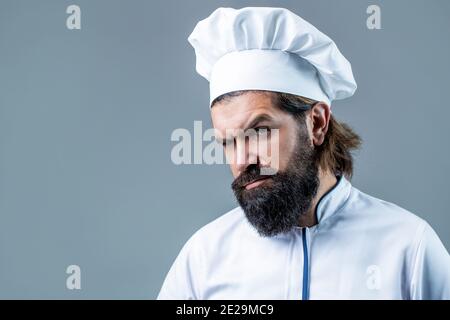 Bärtiger Koch, Köche oder Bäcker. Bärtige männliche Köche isoliert. Kochmütze. Selbstbewusster bärtiger Chefkoch in weißer Uniform. Ernsthaft kochen in weißer Uniform, Koch Stockfoto