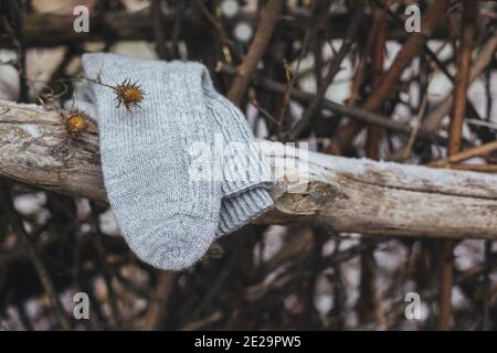 Ein Paar graue handgestrickte Socken auf einem dunklen rustikalen Hintergrund. Natürliche Farben. Stockfoto