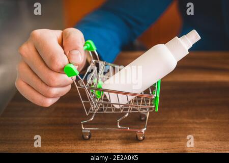 Geschäftsmann Handrollen kleinen Warenkorb mit antiseptischen, Nahaufnahme. Stockfoto