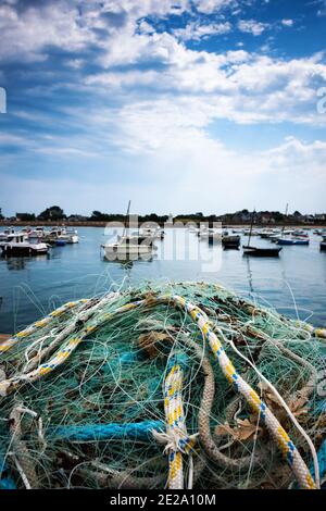 Normandie, Frankreich. Küstenlandschaft. Fischernetz trocknet am Pier nach den Fischern wieder mit frischem Fang; Anlegestellen Boote in der Bucht und Saint-Vaast-la-Hougue Stockfoto