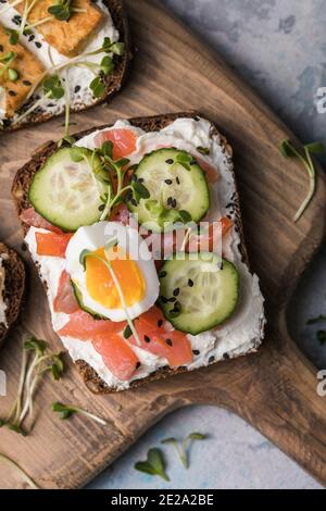 Lachs Toast mit einem Micro-Green auf Holzhintergrund, Konzept der gesunden Ernährung, Sortiment von Bruschetta Stockfoto