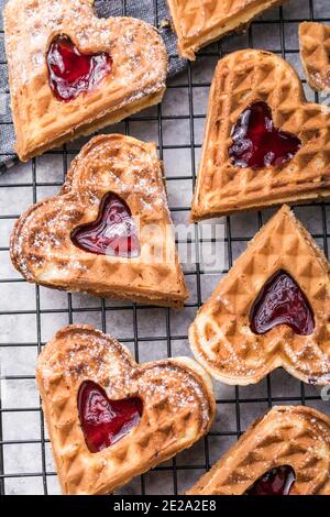 Frisch gebackene hausgemachte herzförmige belgische Waffeln auf grauem Hintergrund. Europäische Backwaren Süßigkeiten. Frühstückskonzept am Valentinstag. Stockfoto