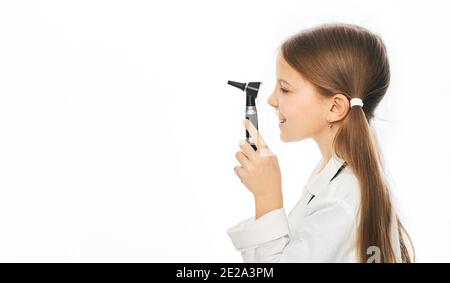 Positive Mädchen in weißen medizinischen Uniform hält Ophthalmoskop, isoliert auf weiß Stockfoto