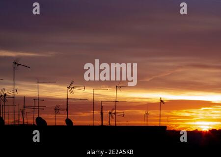 Ein Sonnenuntergang in der Stadt mit Antennen auf den Dächern Stockfoto