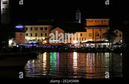 Kroatien, Kvarner-Region, Insel Rab, Panoramablick auf den Hafen von Rab bei Nacht mit Lichtern, die auf dem Wasser reflektieren Stockfoto