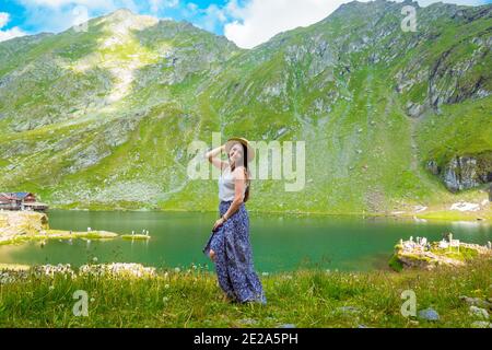 Eine schöne Frau in Adresse und Hut steht in der Nähe von See Balea Stockfoto