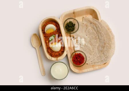 Mittagessen, Thali, Mittagessen auf einer Platte serviert, Thecha, Green Chili Crushed, Knoblauch Chutney, Egg Masala, Cut Boiled Egg, Butter Milk, Top Angle View, Studi Stockfoto