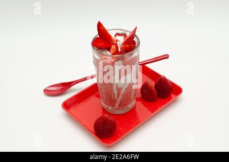 Frische Erdbeermilch mit Sahne schütteln und Erdbeeren schneiden. Draufsicht, Studioaufnahme Stockfoto