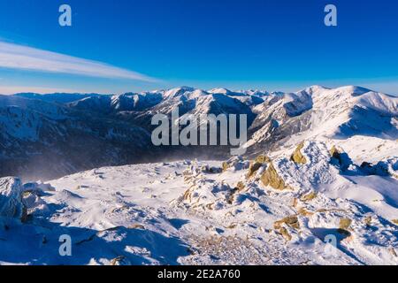 Blick von Kasprowy Wierch auf Kiefernwald mit Winterüberzug im Tal. Schneebedeckte Berggipfel der Tatra, Bukowina Tatrzanska, Polen Stockfoto