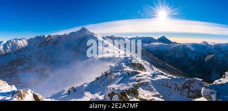 Blick von Kasprowy Wierch auf Kiefernwald mit Winterüberzug im Tal. Schneebedeckte Berggipfel der Tatra, Bukowina Tatrzanska, Polen Stockfoto