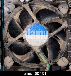 Verschmutzter CPU-Lüfter. Geringe Schärfentiefe, Fokus auf dem Lüfter. Schmutz darunter verstopft den Kühlkörper vollständig, befindet sich aber nicht in der Schärfentiefe. Stockfoto