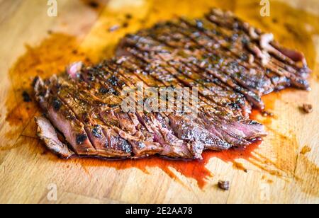 In Scheiben geschnitten Saftig gegrillte marinierte Angus Beef Flank Steak auf Holzbrett. Fertige saftige medium Fleisch geschnitten und fertig zum Servieren. Professionelle g Stockfoto