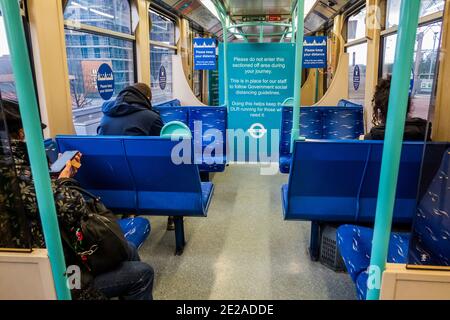 London, Großbritannien. Januar 2021. Das DLR ist noch recht beschäftigt, da es sich dem Massenimpfzentrum in Excel nähert. Keiner der Leute geht dorthin, aber, und sind trotz der neuen nationalen Lockdown, Aufenthalt zu Hause, Anweisungen. Die meisten Reisenden tragen Masken, da sie bereits obligatorisch sind und es überall Warnschilder gibt. Kredit: Guy Bell/Alamy Live Nachrichten Stockfoto