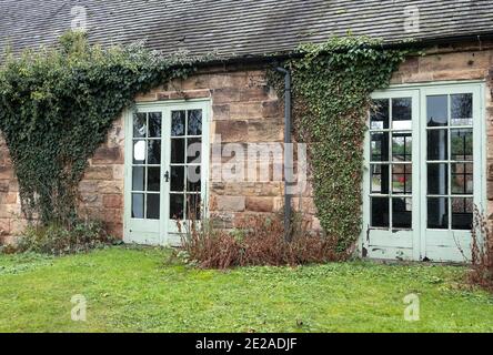 Ein niedriges Steingebäude mit Efeu an den Wänden Stockfoto