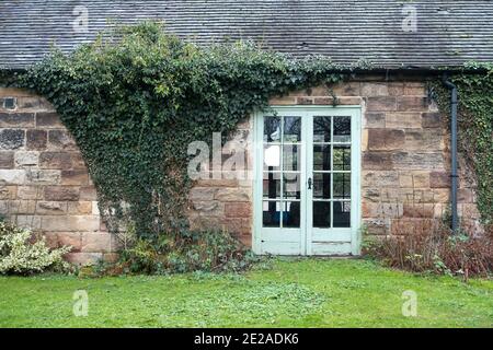 Ein niedriges Steingebäude mit Efeu an den Wänden Stockfoto