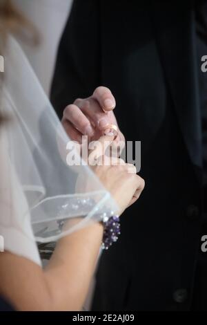 Hochzeitskonzept das Hochzeitsband auf dem Finger der Braut platzieren Stockfoto