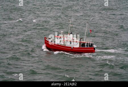 Klassisches hölzernes Fischerboot auf dem Meer mit Anglern an Bord. Stockfoto