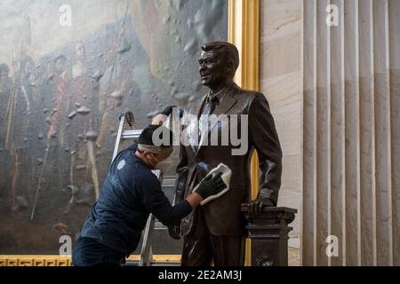 Ein Mann arbeitet am Aufräumen einer Statue des ehemaligen Präsidenten Ronald Reagan in der Rotunde im US-Kapitol in Washington, DC, Dienstag, 12. Januar 2021. Kredit: Rod Lamkey / CNP /MediaPunch Stockfoto