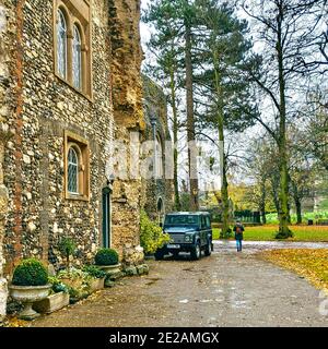 Westfront der Bury St Edmunds Abbey in Häuser umgewandelt. Ein Land Rover parkte draußen mit einer Frau, die bei Winterwetter an der Tür vorbeiging. Stockfoto