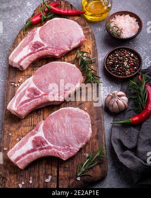 Frische rohe Stücke Fleisch Schweinefleisch, Rindfleisch, Lamm, Hacken auf einem Knochen auf dem Brett, Gewürze Stockfoto