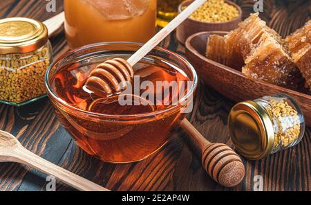 Honig im Glas mit Honig Dipper auf Holzhintergrund Stockfoto