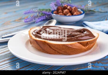 Verteilen von Haselnusscreme auf Brot, Schokoladennussbutter Stockfoto