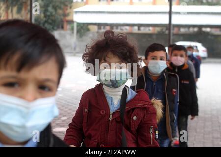 (210113) -- GAZA, 13. Januar 2021 (Xinhua) -- Palästinenser mit Gesichtsmasken werden nach ihrer Wiedereröffnung in einer Schule gesehen, da die COVID-19-Beschränkungsmaßnahmen in Gaza-Stadt am 13. Januar 2021 nachlassen. (Foto von Rizek Abdeljawad/Xinhua) Stockfoto