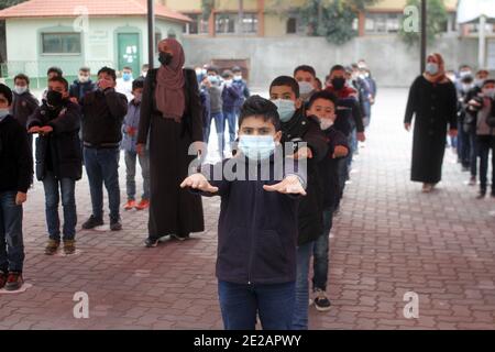 (210113) -- GAZA, 13. Januar 2021 (Xinhua) -- Palästinenser mit Gesichtsmasken machen nach ihrer Wiedereröffnung körperliche Übungen, da die COVID-19-Beschränkungsmaßnahmen in Gaza-Stadt, 13. Januar 2021, nachlassen. (Foto von Rizek Abdeljawad/Xinhua) Stockfoto