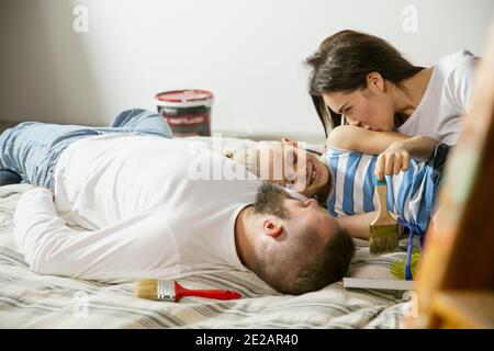 Junges Paar, Familie tun Wohnung Reparatur zusammen selbst. Mutter, Vater und Sohn tun zu Hause Verjüngungskur oder Renovierung. Konzept der Beziehungen, Bewegung, Liebe. Auf Matratze ruhen, Draufsicht Stockfoto