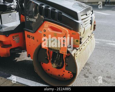 Russland, Sotschi 05.07.2020. Ein Fragment einer orangefarbenen schwarzen Straßenwalze, die auf der Seite der Straße geparkt ist Stockfoto