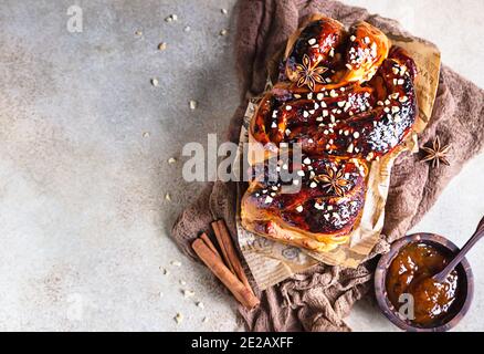 Brioche mit Aprikosenmarmelade, Nüssen, Zimt und Anisstern umrühren. Geflochten oder Brötchen, Babka. Selektiver Fokus. Draufsicht. Stockfoto