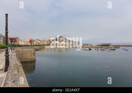 Muxia Fischerhafen und Uferpromenade Teilansicht und Wanderweg Zeichen an der Ampel (Camino dos faros) , La Coruña, Galicien, Spanien Stockfoto