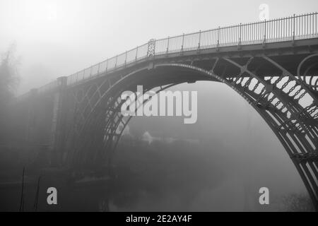 Schwarz-Weiß-Bild Ironbridge Shropshire an einem nebligen Morgen über dem Fluss Severn. Die Brücke ist von Nebel umhüllt, was im Winter eine Unheimlichkeit verleiht Stockfoto