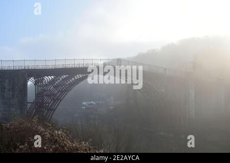 Die Ironbridge, Shropshire, Großbritannien an einem nebligen Morgen über dem Fluss severn. Die Brücke ist von Nebel umhüllt, was an einem Wintertag eine Unheimlichkeit verleiht Stockfoto