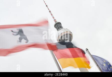 Berlin, Deutschland. Januar 2021. Die Flaggen von Berlin (l-r), Deutschland und Europa fliegen im Wind vor dem Fernsehturm. Sie stehen vor dem Roten Rathaus. Quelle: Annette Riedl/dpa/Alamy Live News Stockfoto