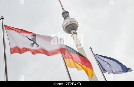 Berlin, Deutschland. Januar 2021. Die Flaggen von Berlin (l-r), Deutschland und Europa fliegen im Wind vor dem Fernsehturm. Sie stehen vor dem Roten Rathaus. Quelle: Annette Riedl/dpa/Alamy Live News Stockfoto