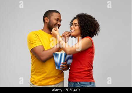 Glückliches afroamerikanisches Paar, das Popcorn isst Stockfoto