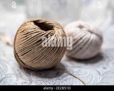 Braune und weiße Fadenkugeln auf dem Tisch Stockfoto
