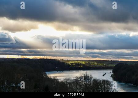 Kiel, Deutschland. Januar 2021. Der Sonnenuntergang ist mit dichten, dunklen Wolken über dem Nord-Ostsee-Kanal zu sehen. Kredit: Frank Molter/dpa/Alamy Live Nachrichten Stockfoto