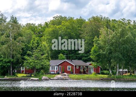 Blick auf rote Ferienhütte am See im Stockholmer Schärengarten, Schweden Stockfoto