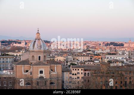 Blick auf das Zentrum von Rom, Italien, von Trastevere über den Tiber, bei Sonnenuntergang. Kirche San Giovanni Battista dei Fiorentini im Vordergrund. Stockfoto