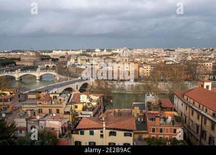 Blick auf das Zentrum von Rom, Italien, über die Dächer von Trastevere auf den Tiber und Brücken. Kirche San Giovanni Dei Battisti am Flussufer. Stockfoto